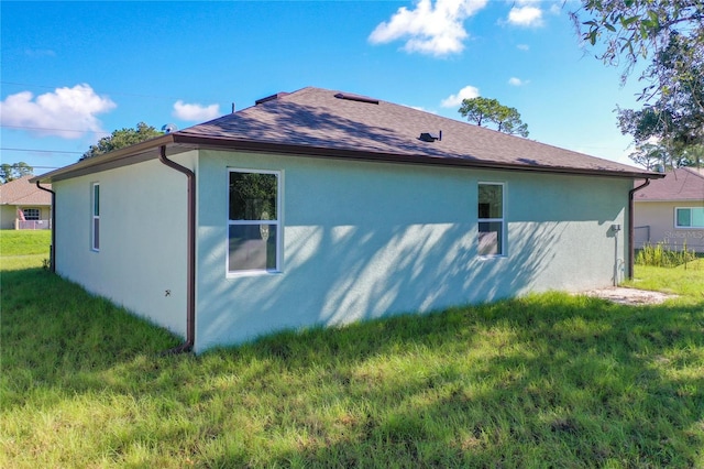 1543 Mackinaw St, North Port, FL 34286 - view of side of home featuring a shingled roof, stucco siding, and a lawn