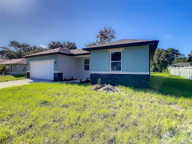 view of front of property featuring a garage and a front lawn