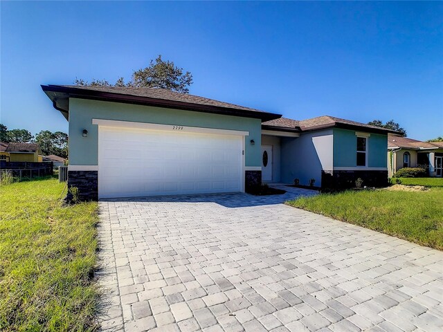 ranch-style home with a front lawn and a garage