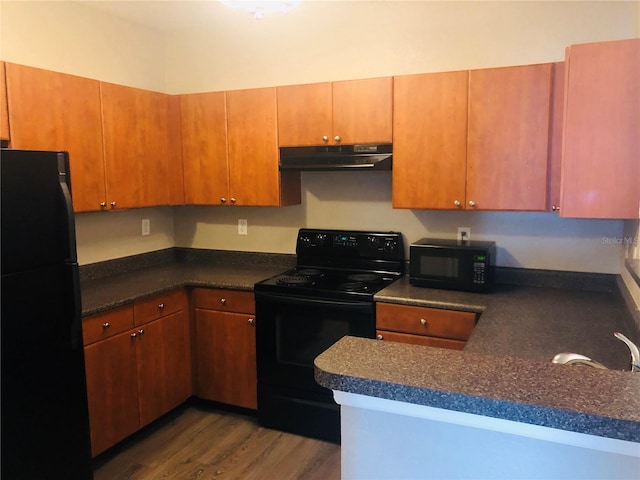 kitchen featuring black appliances and dark hardwood / wood-style flooring