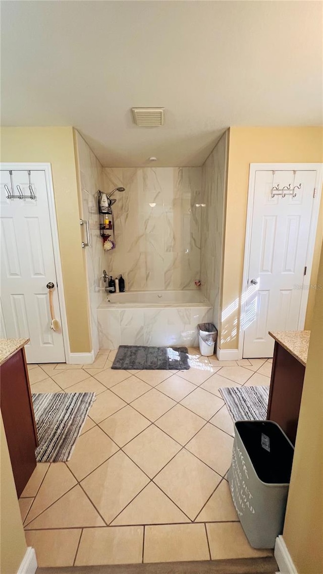 bathroom with tile patterned floors, vanity, and tiled shower / bath