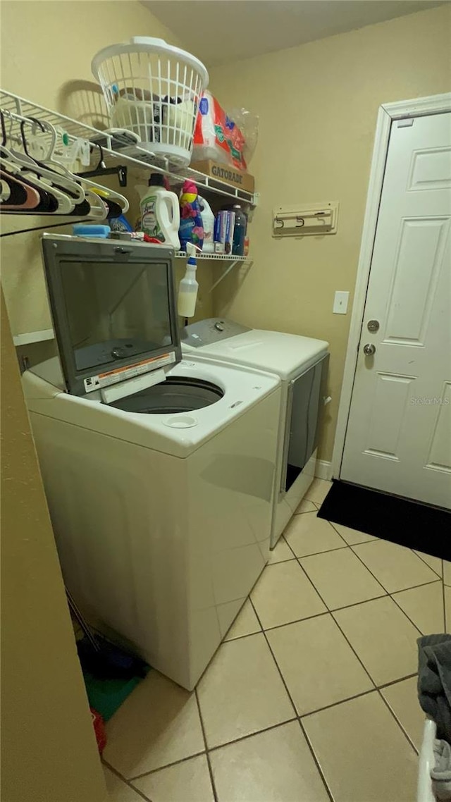 clothes washing area with separate washer and dryer and light tile patterned floors