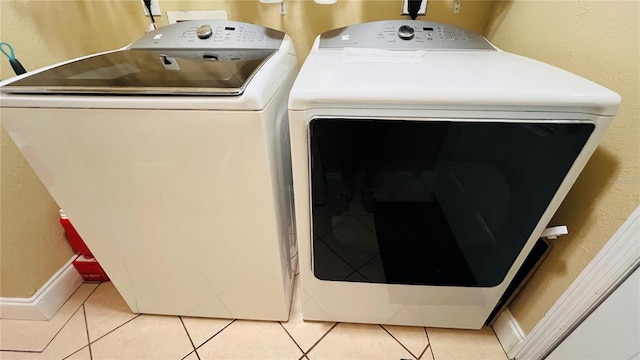 washroom featuring washing machine and dryer and tile patterned flooring