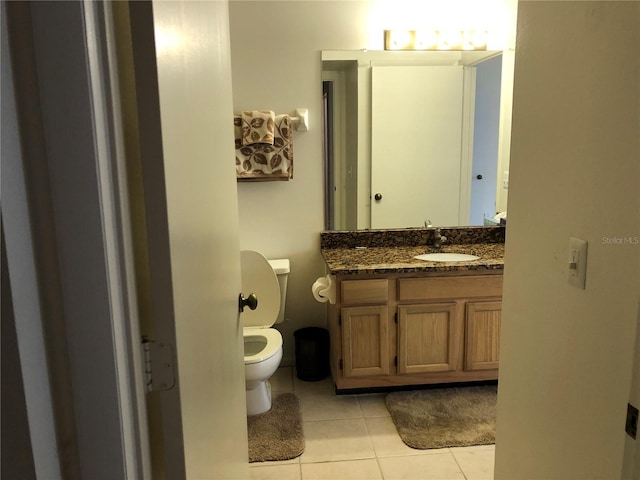 bathroom featuring toilet, tile patterned floors, and vanity