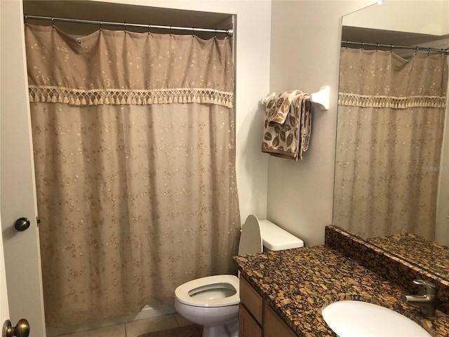 bathroom featuring toilet, tile patterned flooring, walk in shower, and vanity