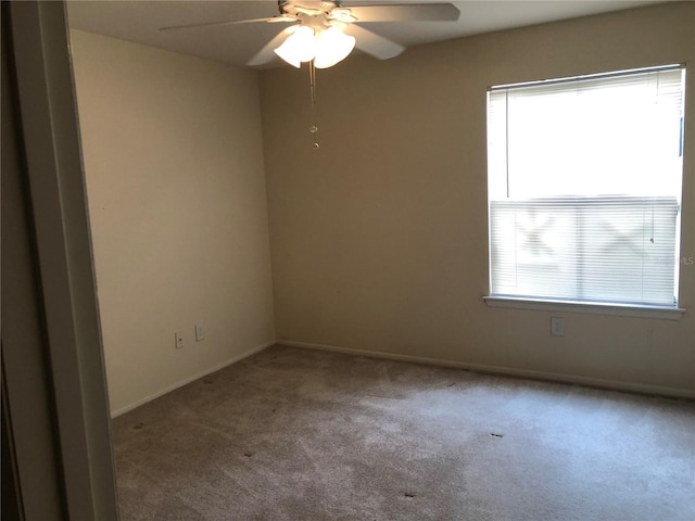 empty room featuring carpet floors and ceiling fan