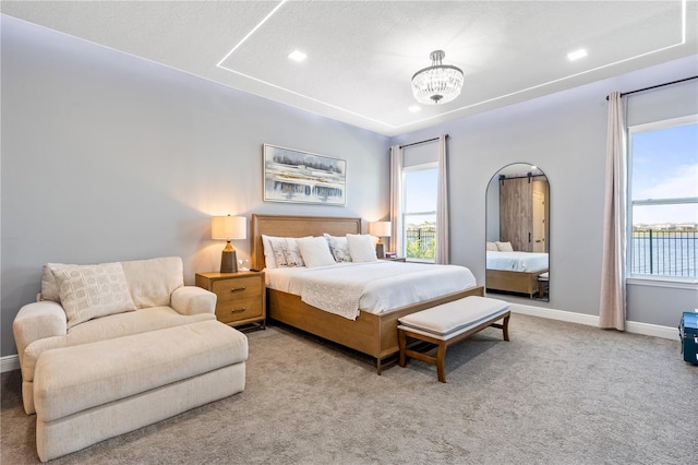 bedroom featuring light colored carpet, a textured ceiling, and an inviting chandelier