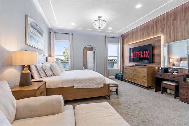 bedroom with light colored carpet, multiple windows, a chandelier, and a textured ceiling