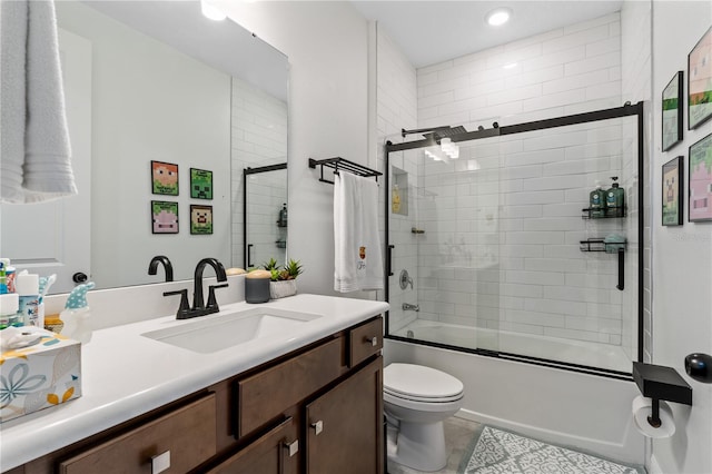 full bathroom with bath / shower combo with glass door, tile patterned flooring, vanity, and toilet