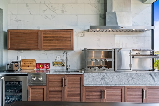 kitchen with wall chimney exhaust hood, beverage cooler, and sink