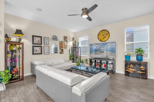 living room featuring light hardwood / wood-style flooring and ceiling fan