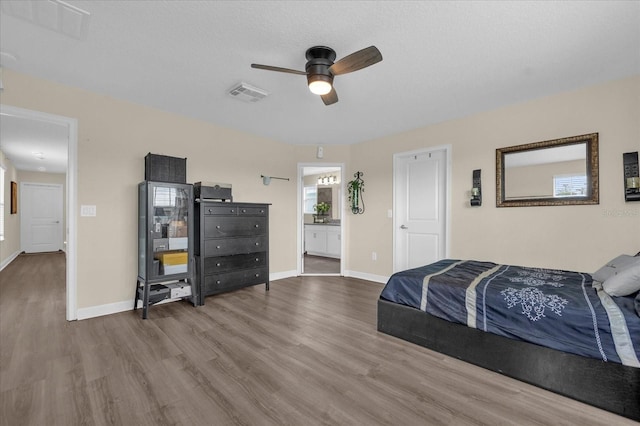 bedroom featuring wood-type flooring, connected bathroom, and ceiling fan