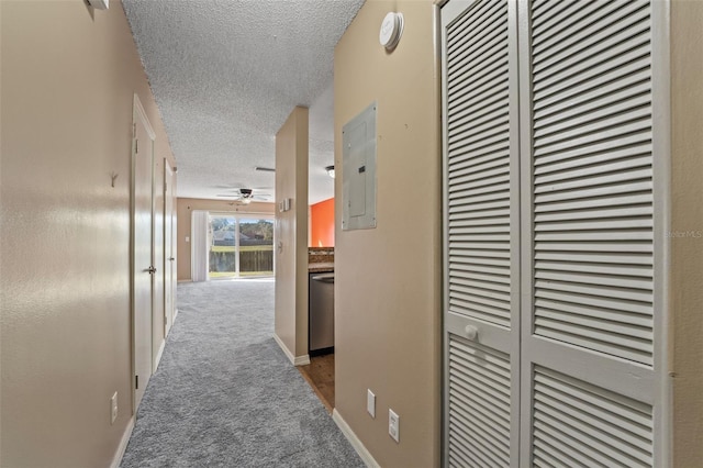 corridor featuring carpet flooring, electric panel, and a textured ceiling