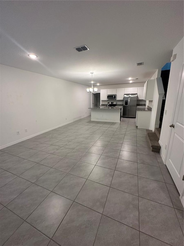 unfurnished living room with light tile patterned floors and a chandelier