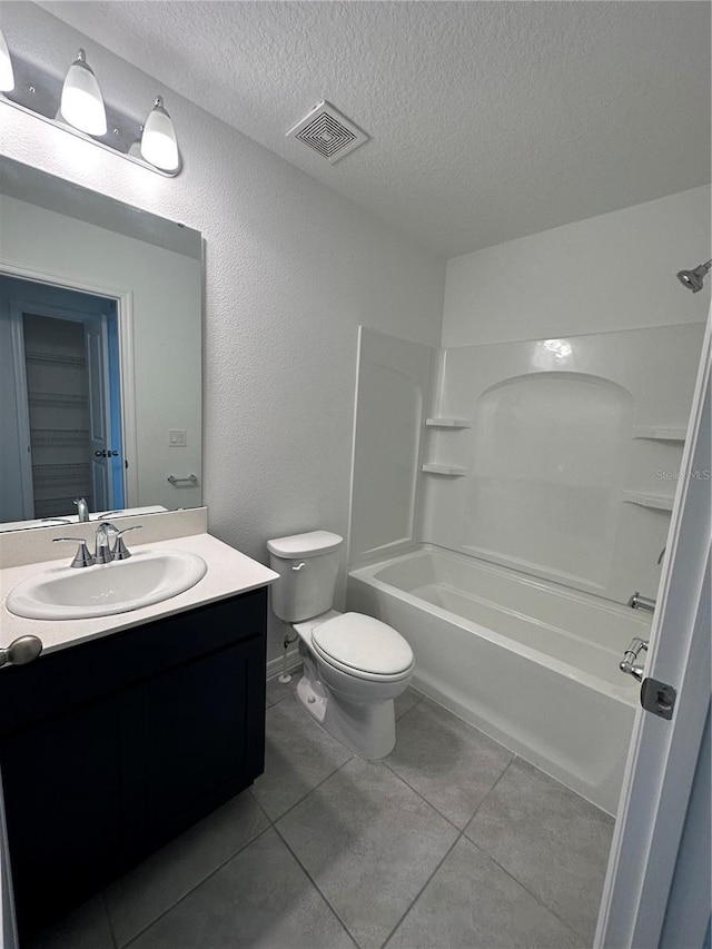 full bathroom featuring bathing tub / shower combination, tile patterned flooring, a textured ceiling, and toilet