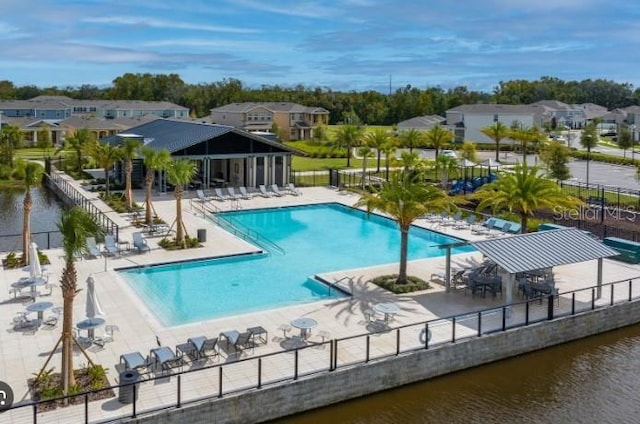 view of swimming pool with a patio and a water view