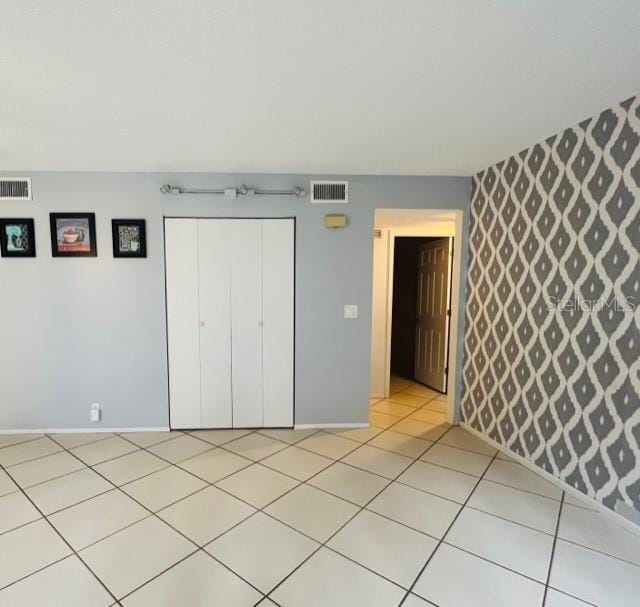 unfurnished bedroom featuring light tile patterned flooring and a closet