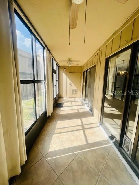 unfurnished sunroom featuring a wealth of natural light and ceiling fan