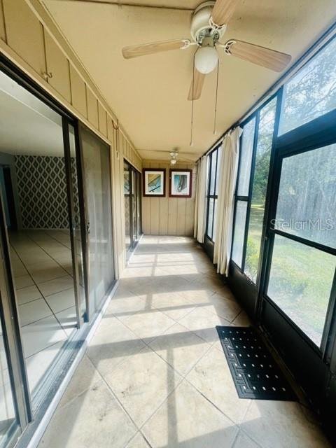 unfurnished sunroom featuring ceiling fan