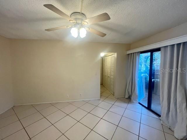 tiled empty room featuring a textured ceiling and ceiling fan