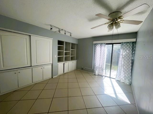 tiled spare room featuring ceiling fan and a textured ceiling