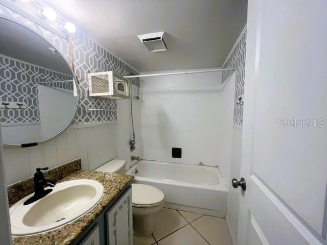 full bathroom with washtub / shower combination, tile patterned floors, vanity, and toilet