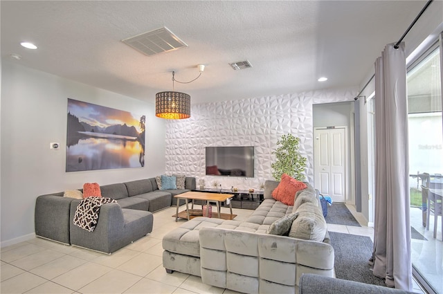 living room with a textured ceiling and light tile patterned flooring