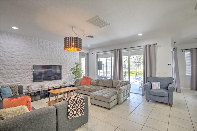 living room with an inviting chandelier, a textured ceiling, and light tile patterned flooring