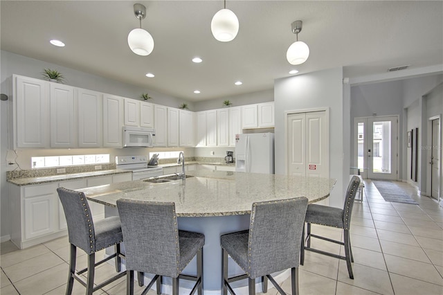 kitchen with white cabinetry, sink, an island with sink, white appliances, and pendant lighting