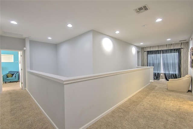 hall featuring light colored carpet