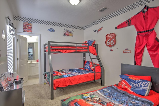 bedroom featuring a textured ceiling, light carpet, and connected bathroom