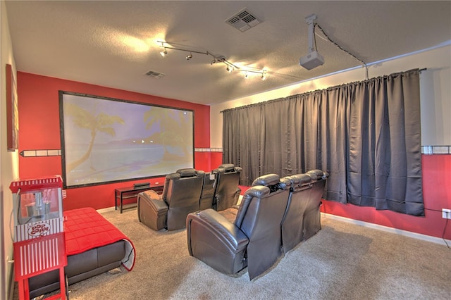 home theater room with carpet, a textured ceiling, and track lighting