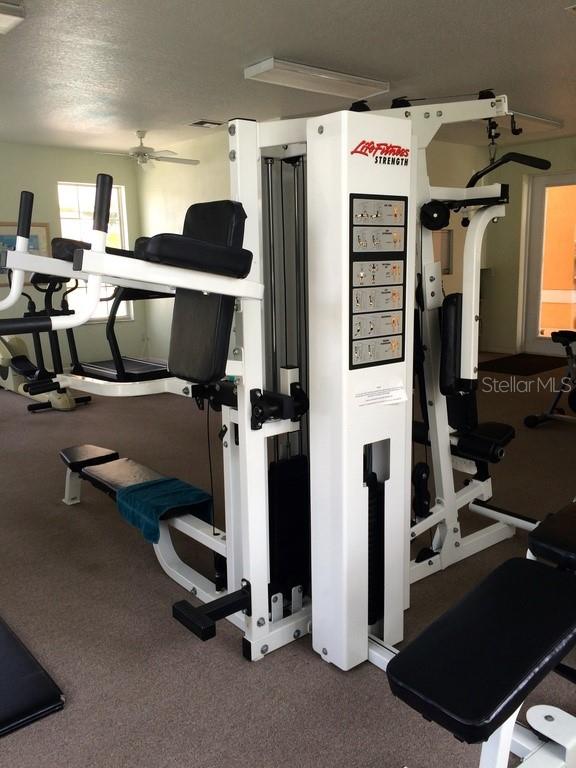 exercise room featuring a textured ceiling and ceiling fan