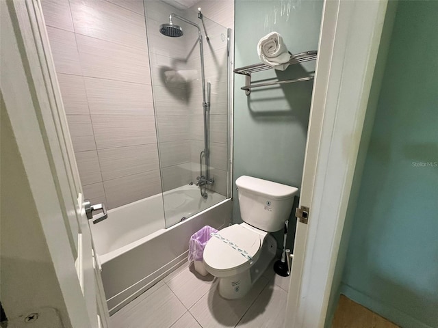 bathroom featuring toilet, tiled shower / bath, and tile patterned flooring