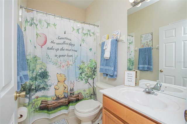 bathroom with toilet, vanity, and tile patterned flooring