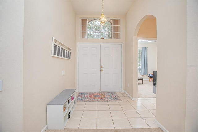 tiled foyer entrance featuring a towering ceiling