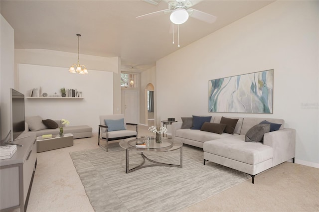 carpeted living room with ceiling fan with notable chandelier