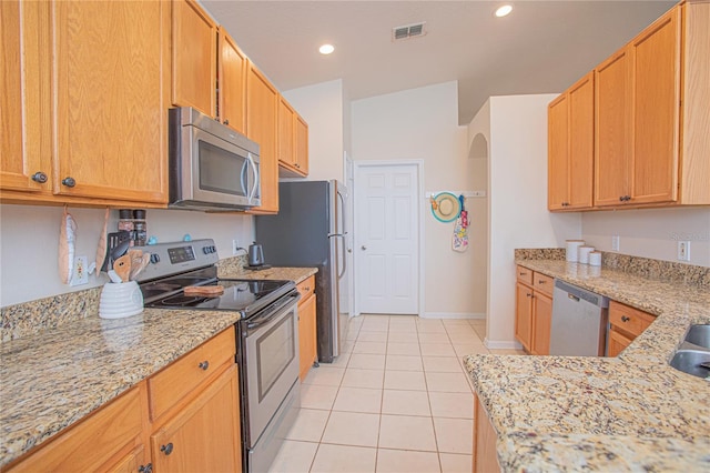 kitchen featuring light stone countertops, light tile patterned floors, and appliances with stainless steel finishes