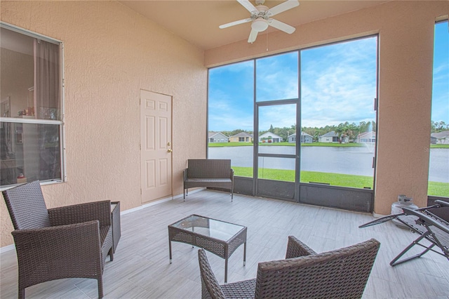 sunroom with a water view and ceiling fan