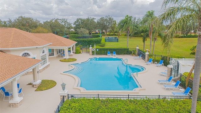 view of pool featuring a patio and a yard