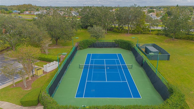 view of sport court with a yard