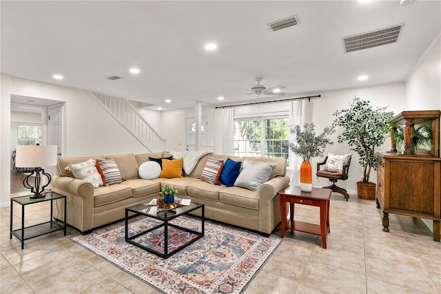 living room featuring ceiling fan, light tile patterned floors, and crown molding