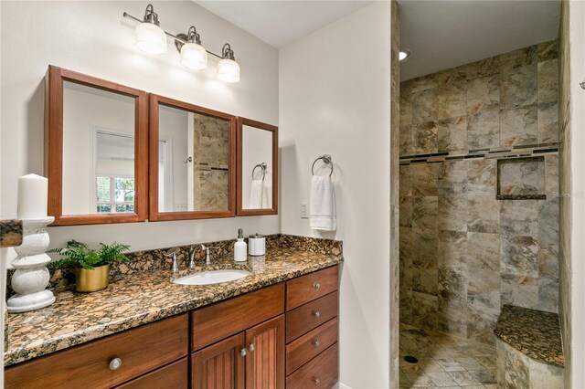 bathroom with vanity and a tile shower