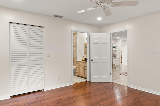 unfurnished bedroom with light hardwood / wood-style floors, ceiling fan, connected bathroom, and a closet