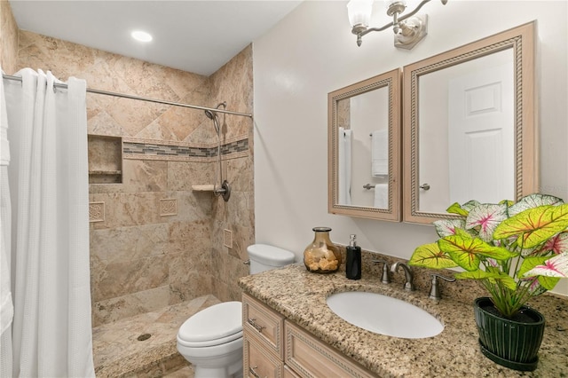 bathroom with toilet, vanity, and walk in shower