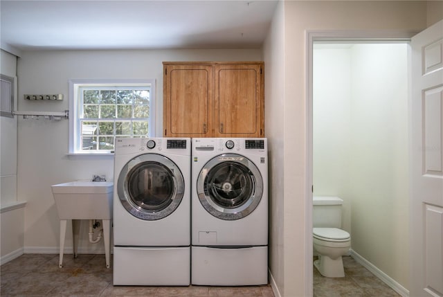 washroom featuring washing machine and dryer and light tile patterned flooring