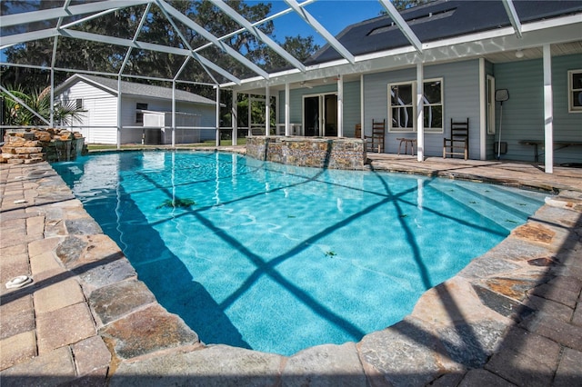 view of swimming pool featuring glass enclosure, pool water feature, and a patio area