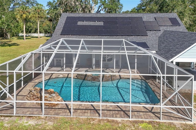 view of swimming pool with glass enclosure and a patio