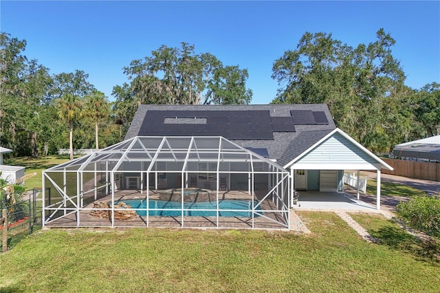 back of property with glass enclosure, a patio area, and a yard