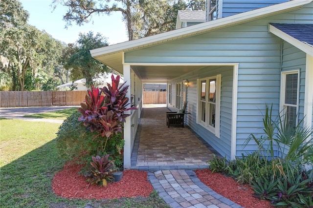 entrance to property with a patio and a lawn